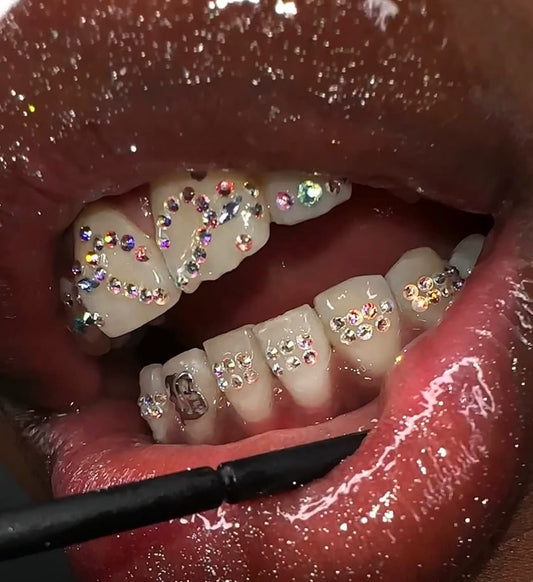 Professional tooth gem application process showing a sparkling crystal gem being carefully applied to a clean tooth using dental adhesive and precision tools, highlighting a safe and non-invasive cosmetic procedure.